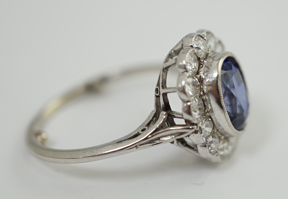 A mid 20th century white gold and millegrain set sapphire and diamond oval cluster ring